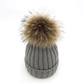 Détails de la maille du bonnet d'hiver gris foncé avec un grand pompon marron - Gris