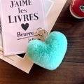 Mint green plush heart keychain with gold ring on dark wood desk with coffee cup - Green