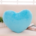 Morbido cuscino di peluche blu a forma di cuore su un divano beige in casa - Celeste