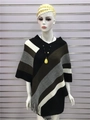 Dettaglio del poncho in maglia con nappe, strisce diagonali e orlo con frange - Caffè Nero