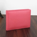 Detailed close-up showing texture of pink pebbled leather driver license cover holder. - Pink