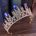 Dettaglio di corona barocca dorata con gemme blu a goccia e cristalli su libri d'epoca - Base Oro Chiaro & Blu Reale