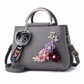 Grey pebbled leather handbag with gold handle and 3D floral accents with pompom charm - Dark Gray