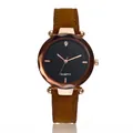 Détail d'une montre en or rose avec lunette en verre facetté marron et cadran noir mat - Marron