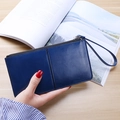 Blaue Leder-Geldbörse für Damen mit Handschlaufe in einer Lifestyle-Szene gezeigt - Königsblau