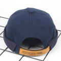 Dettaglio del cinturino in pelle e incisione 1986 sul berretto docker blu navy - Regolabile / Blu navy