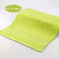 Starfruit yellow cotton face towel with textured geometric border and soft pile - 34x34cm / Starfruit Yellow