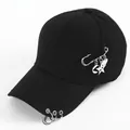 Detail of black cotton baseball cap with silver metal rings and hanging celestial charms - Safety Pin and Metal Ring