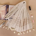 Detailed close-up of beige scarf with geometric lace embroidery and soft fringe tassels - Beige