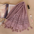 Detail of pink lace scarf with tassel fringe, styled with perfume and elegant accessories - Leather Purple