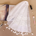 Close-up of white shawl featuring intricate floral lace embroidery and soft tassel fringes - White