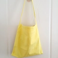 Detail of solid yellow canvas tote bag hanging on a white wooden door in a home setting - Light Yellow