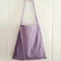 Detail view of solid lavender canvas tote bag hanging on a door in minimalist style - Light Purple