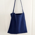 Detail of a dark blue canvas tote bag hanging on a white door with long shoulder straps - Navy Blue