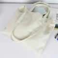 Minimalist white canvas tote bag with dual shoulder straps in a flat lay stationery scene - Off White