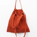 Detail of orange canvas tote bag with contrast white stitching and double strap design - Brick Red