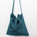 Detail of teal canvas tote bag showing durable woven texture and versatile three-strap design - Lake Blue