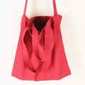 Detail of red canvas tote bag featuring dual shoulder straps and sturdy hand-held handle - Burgundy