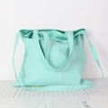 Detail of mint green canvas tote bag with dual handles and long shoulder strap - Mint Blue