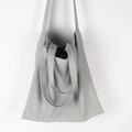 Detalle del bolso tote de lona gris con correas dobles y asa corta de mano - Gris claro