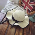 Beige woven straw sun hat with black bow and wavy brim on a rustic wooden desk - M (56-58cm) / Wave Brim Bow Style / Beige
