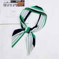 Dettaglio di un foulard in seta a righe annodato a fiocco nei colori verde, bianco e nero - 7 Striscia Verde