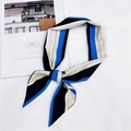 Dettaglio del lussuoso foulard in seta a righe drappeggiato su una rivista - 6 Striscia Blu