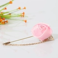 Pink satin rose lapel pin with gold chain and hollow leaf detail on white surface - Pink