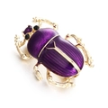 Macro shot of vintage beetle brooch featuring purple enamel and gold-tone rhinestone details - Purple
