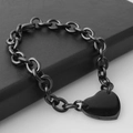 Nahaufnahme eines schwarzen Edelstahl-Gliederarmbands mit einem Herzanhänger - Schwarz