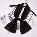 Elegant long black silk-satin skinny scarf tied on a hanger with fashion accessories - Black