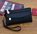 Detail view of black embossed lattice clutch bag with metal zipper and wrist strap - Black