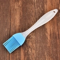 Blue silicone oil brush with translucent white handle for BBQ on dark wood background - Blue