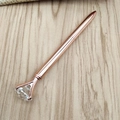 Penna a sfera in metallo oro rosa con grande cristallo a diamante su sfondo di legno - Oro rosa