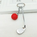 Detailed macro view of the realistic red golf ball and silver club charm on the keychain - Red