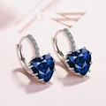 Macro detail of heart-shaped blue zircon drop earrings with pavé crystals in silver setting - Dark Blue Zirconia