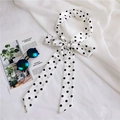 Detailed view of polka dot long skinny silk scarf tied in bow on white fabric - Polka Dot White