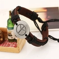 Gros plan d'un bracelet en cuir vintage avec signe de paix argenté et corde tressée - Noir