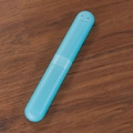 Custodia blu per spazzolino da denti portatile con sorriso su tavolo in legno - Blu trasparente