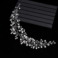 Silver bridal headband with white pearls and crystal branches on elegant display - Silver