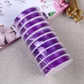 Rolls of purple elastic crystal string for DIY jewelry making on textured background - 0.8mm / Dark Purple