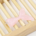 Gedetailleerd beeld van roze hars zeemeerminstaart met glitter op bamboe standaard - Roze