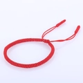Detail of red handmade braided Vajra knot bracelet with adjustable drawstring closure - Red