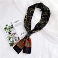 Close-up of black silk scarf with gold chain patterns and green-red striped detail - Black Metal Chain