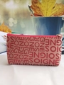 Detail of beige woven pouch with red SOIGNE jacquard lettering and zipper closure - Burgundy