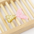 Macro view of a resin mermaid tail pendant with pink gradient and shimmering glitter - Pink Gold