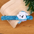 Close-up of blue sequin Christmas slap bracelet with a plush polar bear on wood - Sequin Bear - With LED