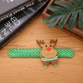 Close-up of a green sequin Christmas reindeer slap bracelet on a rustic wooden desk - Sequin Reindeer - No Light