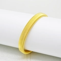 Detailansicht eines goldenen Federarmbands für Herren auf einem weißen Ständer - Gold