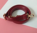 Detail eines roten PU-Leder Ersatzriemens mit goldener Metallschnalle und Verstellung - Burgunderrot